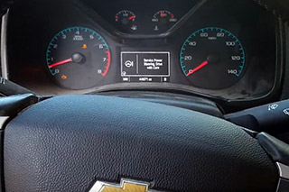 The driver info screen displaying a warning about servicing power steering
