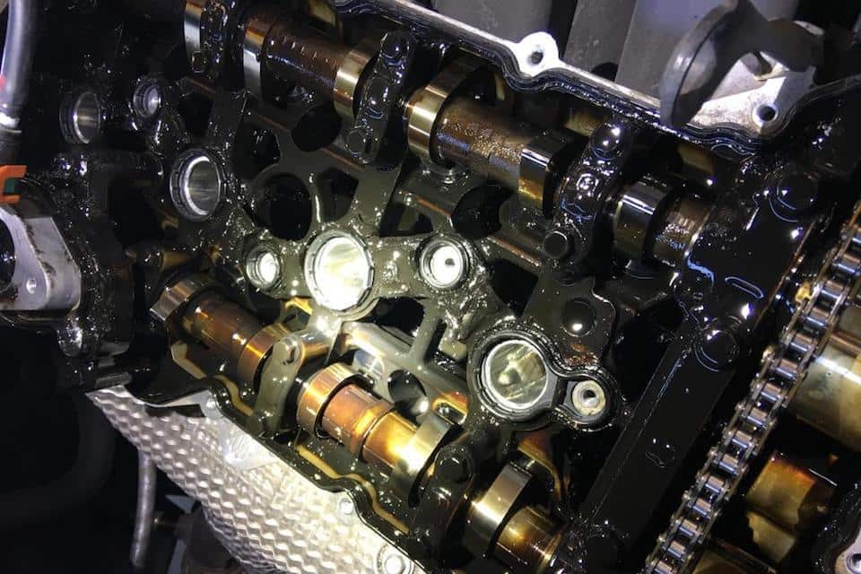 A Nu engine with the pistons, cam shaft, and timing chain covered in oil.