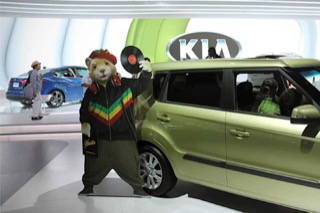 A hamster holding a record in front of a green Kia Soul, from an advertising campaign.