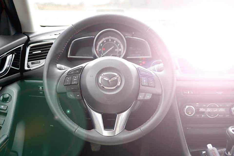 Interior view of Mazda with intense glare off dashboard