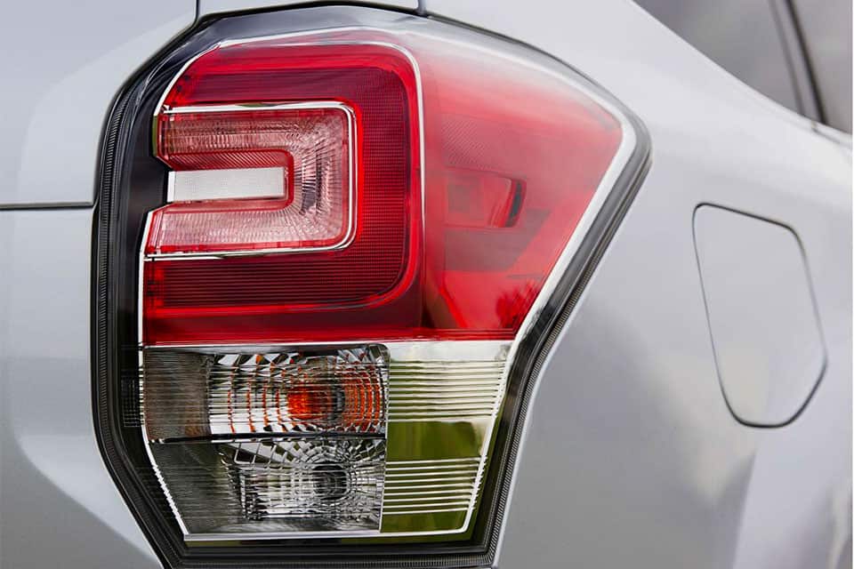 Close-up of a brake light with a red lens on top, clear lens on bottom.