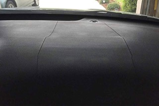 An Acura dashboard with two cracks running perpendicular to the windshield
