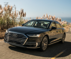 A black S8 driving down a road on a sunny day