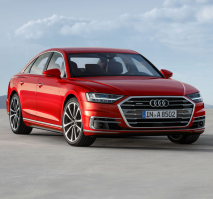 Front three-quarters of a red Audi with a cloudy sky in the background