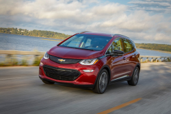 A red Bolt EV driving down the road