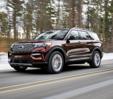 A maroon Ford Explorer on a snowy road