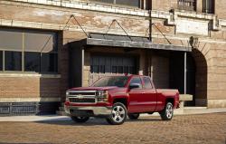 A red Silverado truck in front of an old brick factory