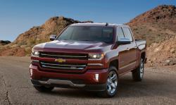 A red Silverado truck in front of mounds of dirt