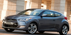 A gray Hyundai Velostar in front of a building