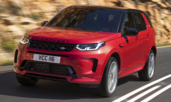 A red Discovery Sport drives down the road