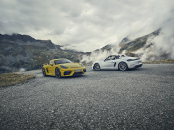 Two Porsche vehicles on a foggy mountain road