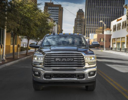 A Ram truck on a city street with tall buildings in the background