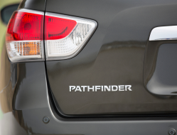 The red lens of a brake light above the Pathfinder emblem on the trunk