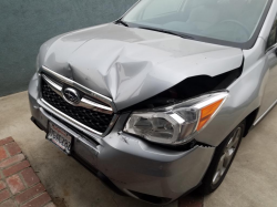 The crumpled hood of a gray Subaru vehicle