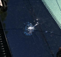 A large spider web crack in a windshield, just above the dash
