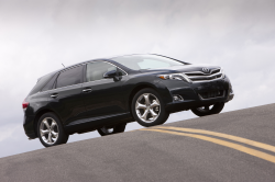 A black Venza at the top of a hill on a paved road.