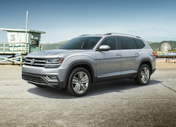 A silver Atlas parked on concrete near a beach