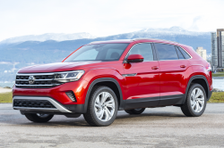 A red Atlas SUV with mountains in the background